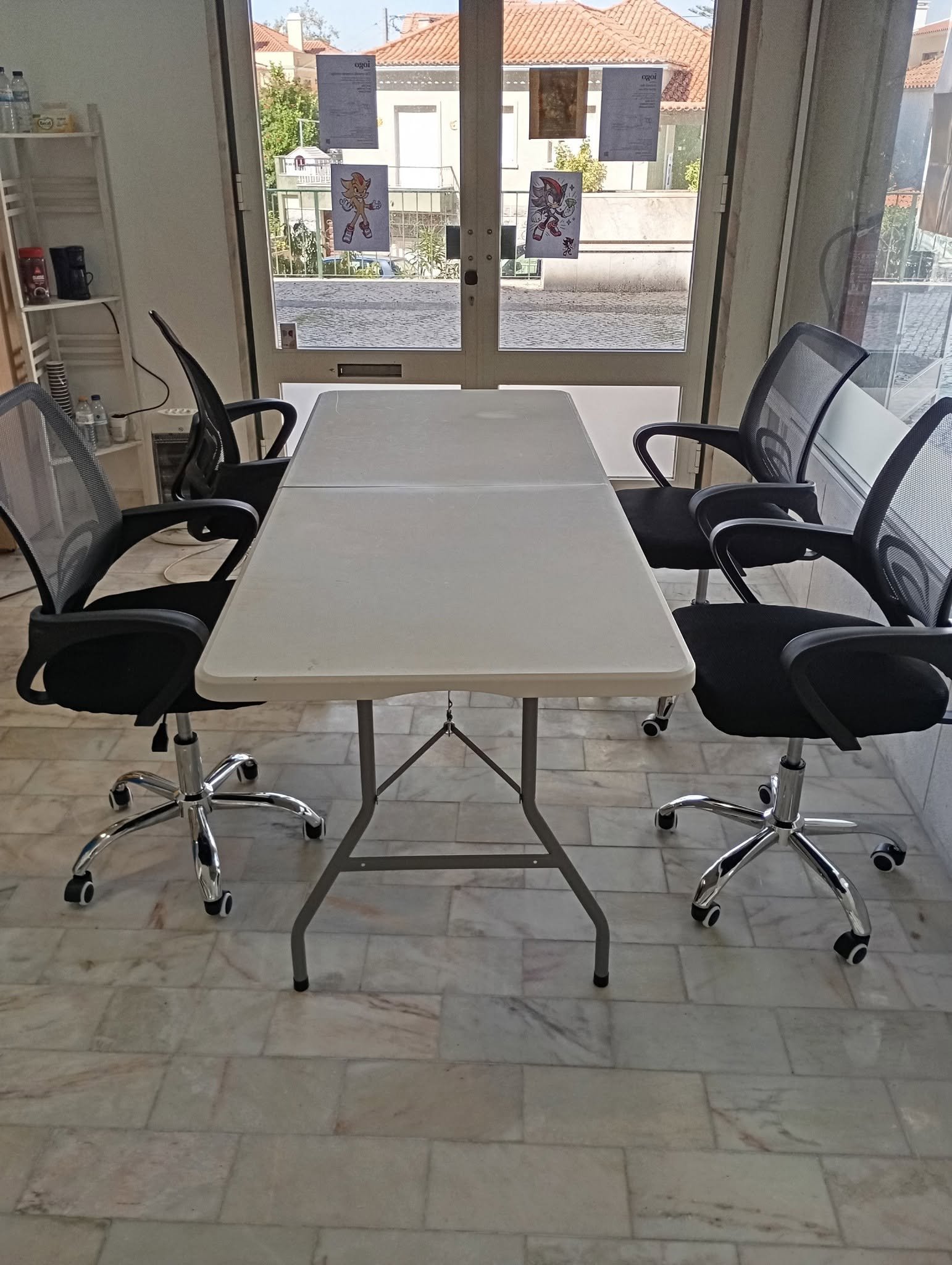 Mesa de trabalho junto à porta de vidro no espaço iogo, Sintra