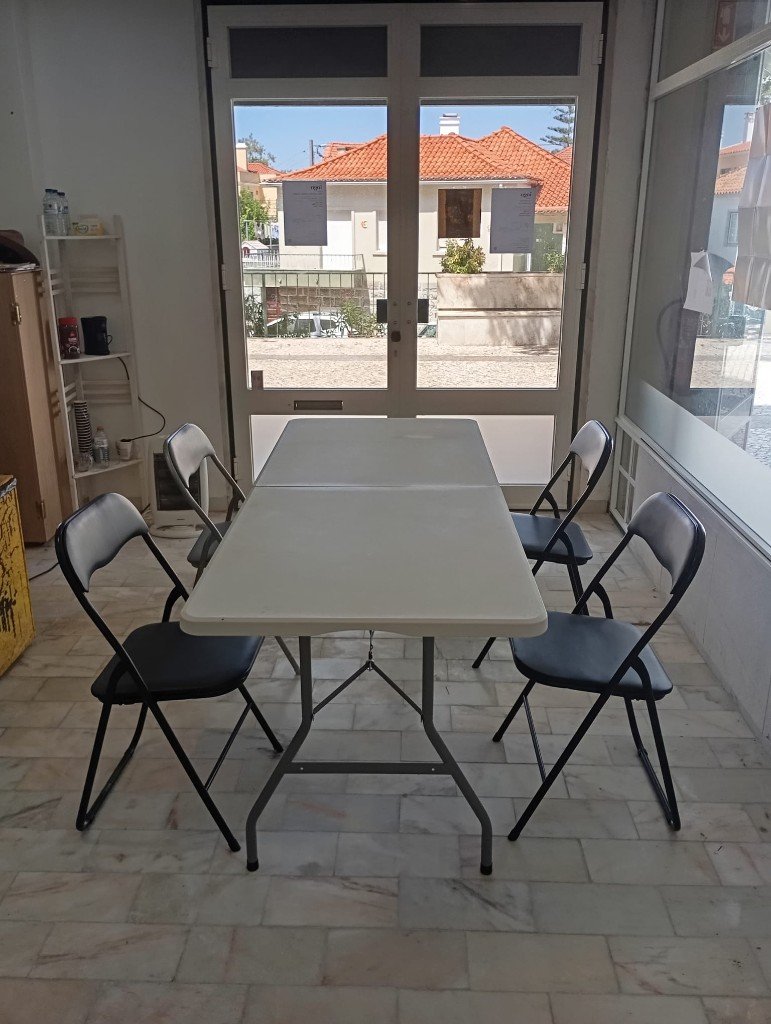 Mesa de trabalho junto à porta de vidro no espaço iogo, Sintra